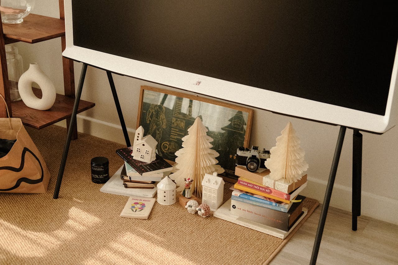 Warm and cozy living room corner featuring holiday decor, books, and art for a festive atmosphere.